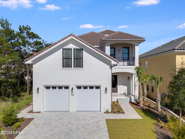 mediterranean / spanish-style house featuring a garage, a front lawn, and a balcony