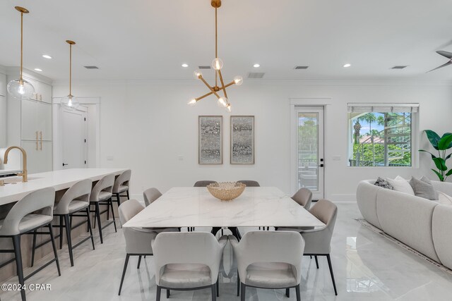 dining area featuring crown molding, an inviting chandelier, and sink