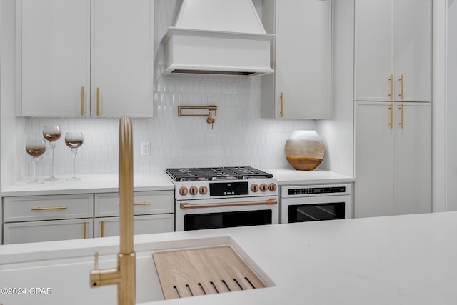 kitchen with oven, tasteful backsplash, gas stove, and custom exhaust hood