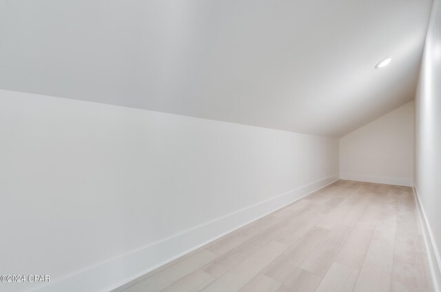 bonus room featuring light wood-type flooring and vaulted ceiling