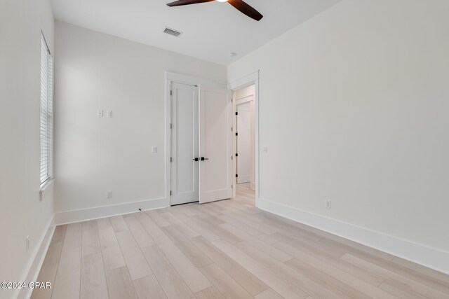 empty room with ceiling fan and light hardwood / wood-style floors