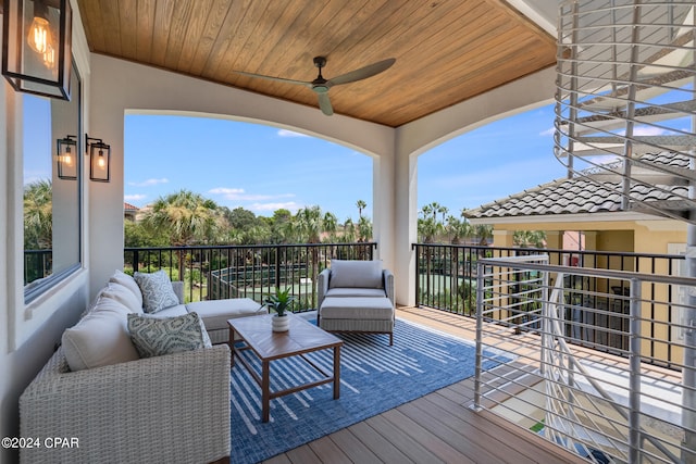 wooden terrace with an outdoor living space and ceiling fan