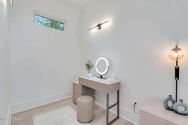 bedroom featuring a raised ceiling, ceiling fan, connected bathroom, and light hardwood / wood-style floors