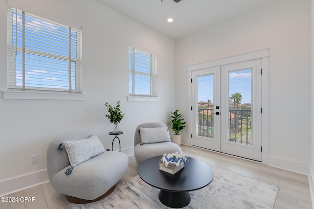 living area with french doors and light hardwood / wood-style flooring