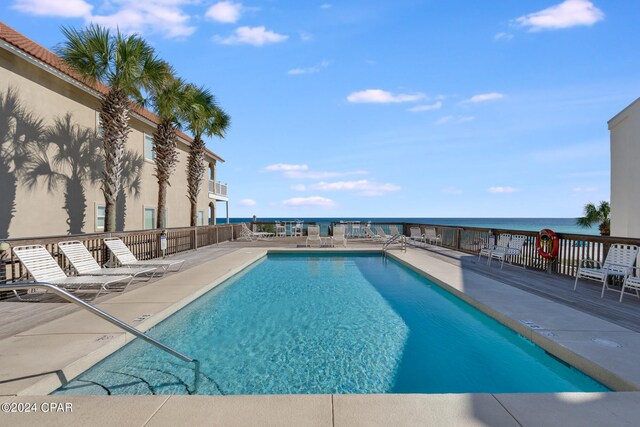 view of pool featuring a patio and a water view