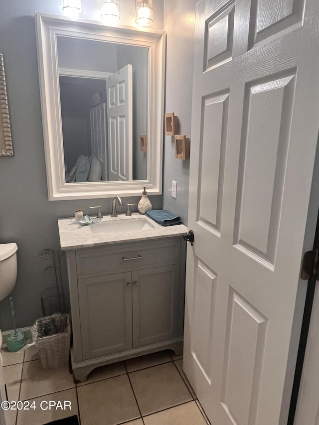 bathroom with tile patterned flooring, vanity, and toilet