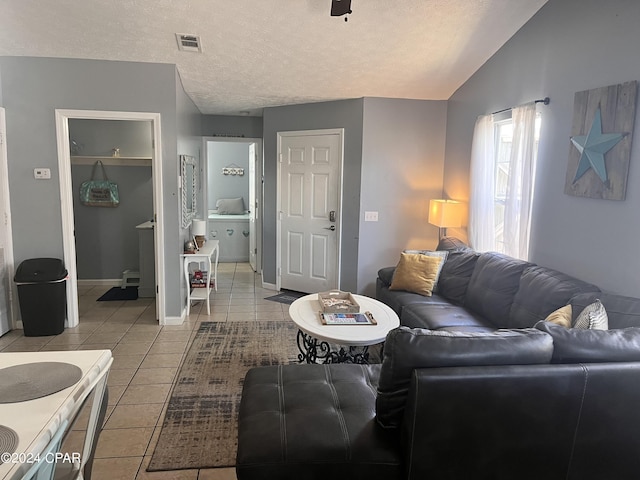 tiled living room featuring a textured ceiling, vaulted ceiling, and ceiling fan