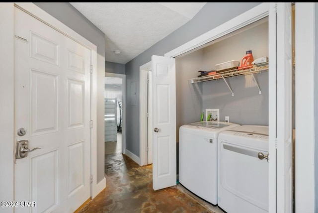 laundry area featuring washer and clothes dryer and a textured ceiling