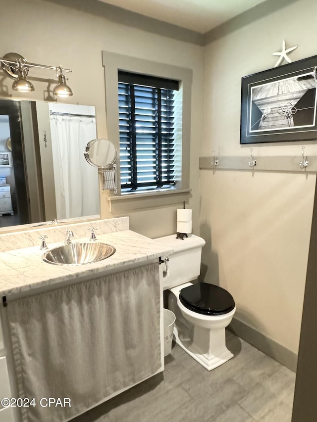 bathroom with hardwood / wood-style floors, vanity, and toilet