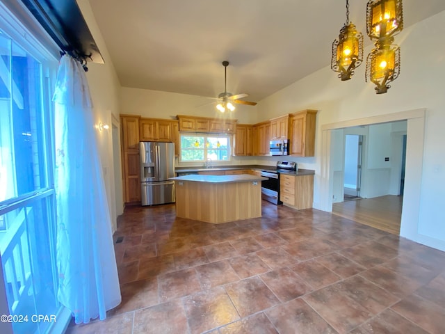 kitchen with a kitchen island, sink, ceiling fan with notable chandelier, and appliances with stainless steel finishes