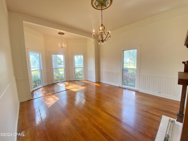 interior space featuring plenty of natural light, wood-type flooring, and a chandelier