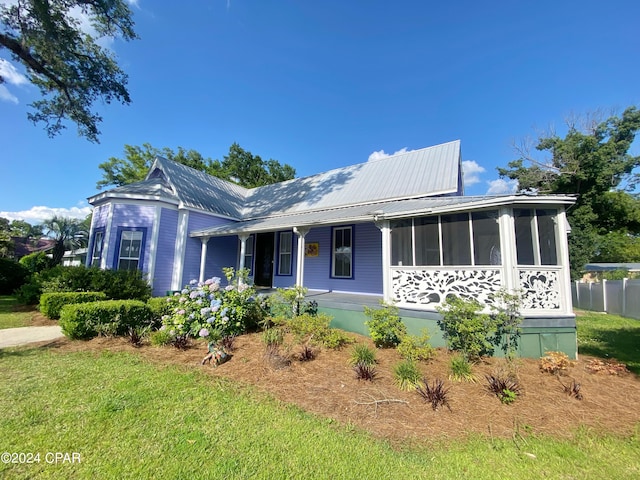 view of front of house featuring a front yard, a sunroom, and a porch