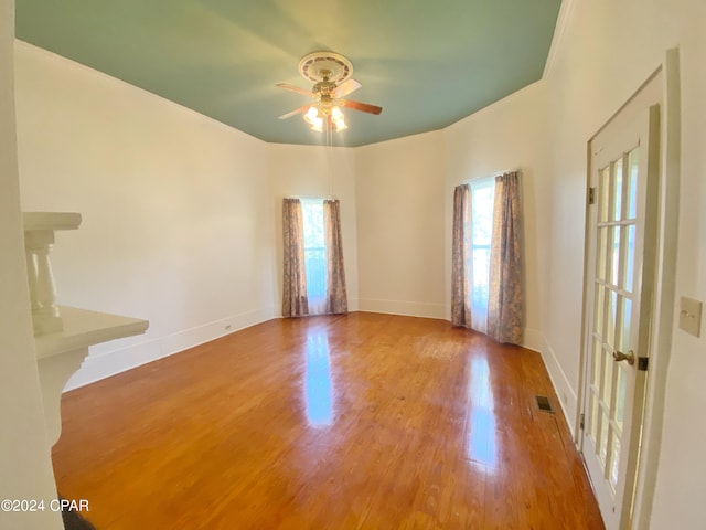 empty room with hardwood / wood-style floors and ceiling fan