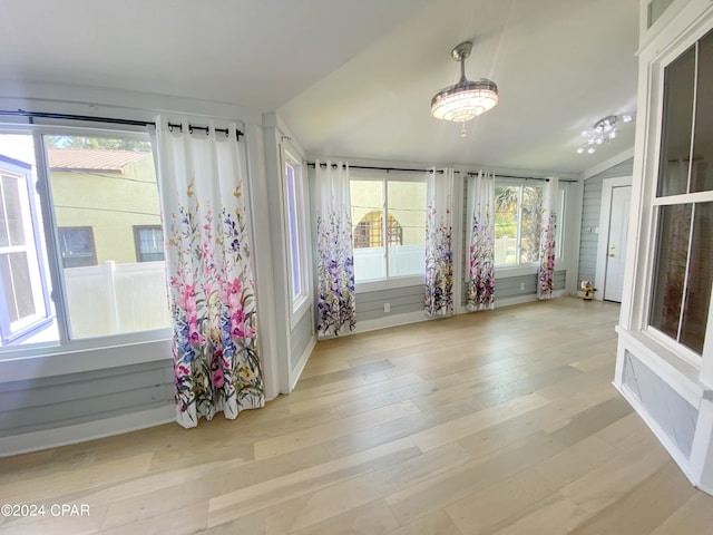 unfurnished sunroom featuring plenty of natural light and vaulted ceiling