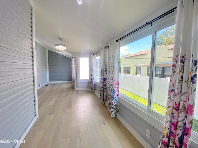 hall featuring wooden walls and light hardwood / wood-style floors