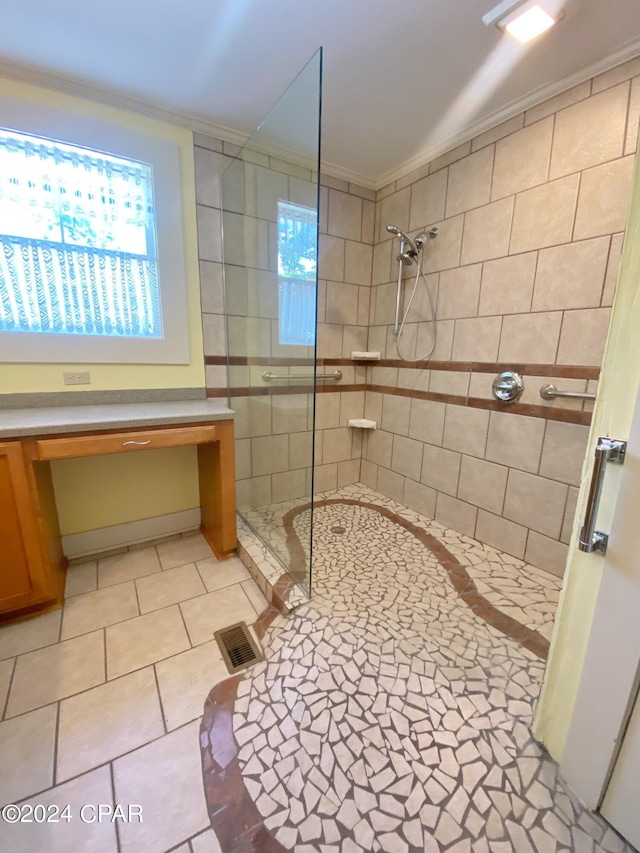 bathroom with crown molding, tile walls, tile patterned floors, and a tile shower