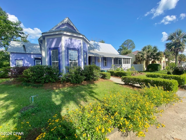 view of front of house featuring covered porch and a front yard