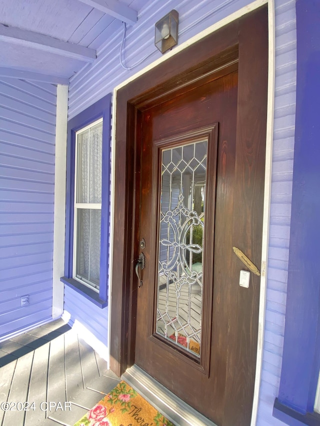 view of exterior entry featuring covered porch