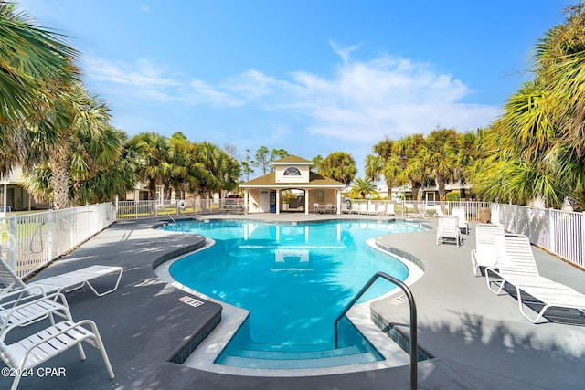 pool with a patio area and fence