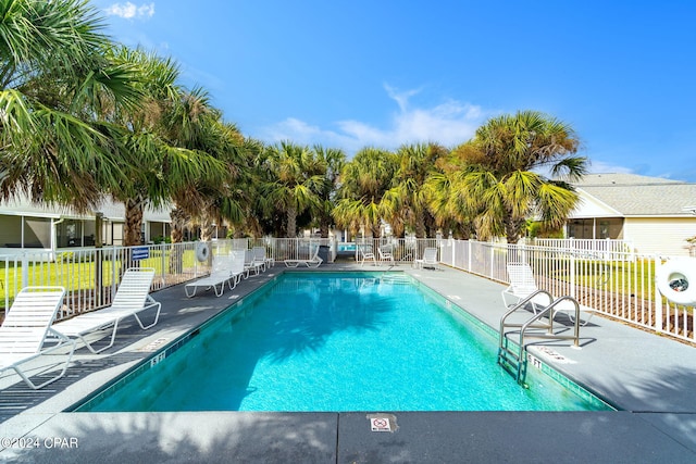 community pool with a patio and fence