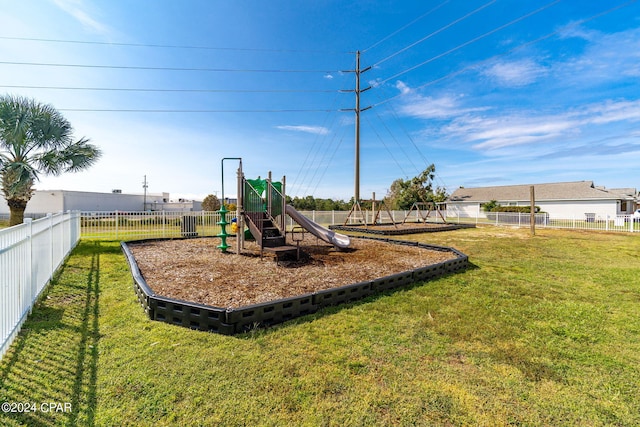 community jungle gym with a yard and fence