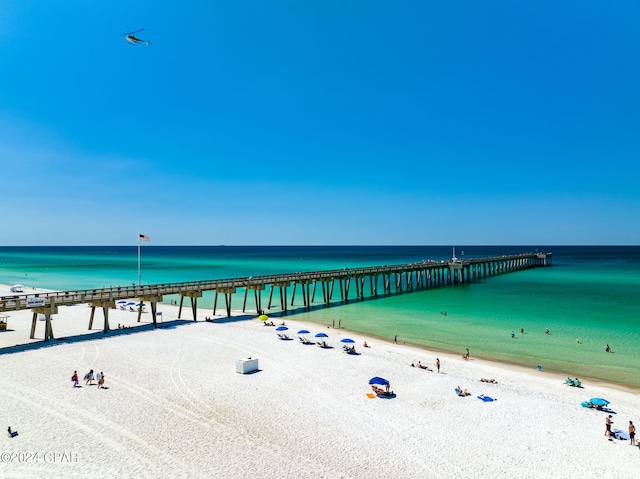 property view of water featuring a pier and a view of the beach