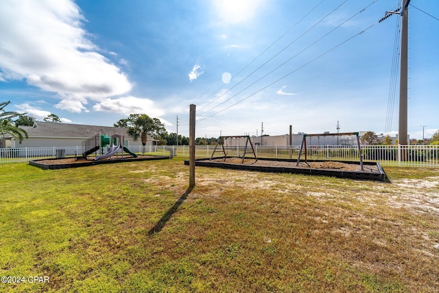 view of yard featuring playground community and a fenced backyard