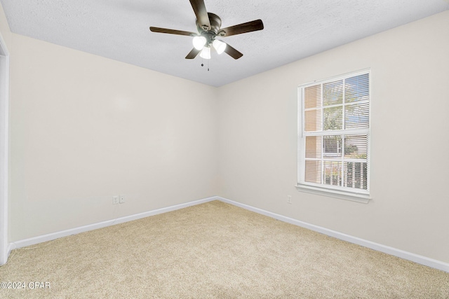 empty room featuring ceiling fan, a textured ceiling, baseboards, and carpet floors