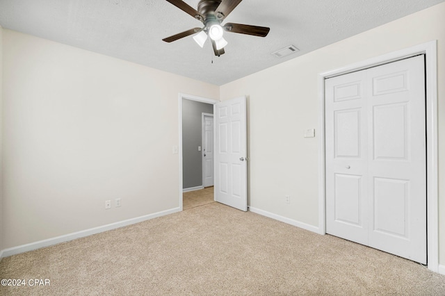 unfurnished bedroom featuring visible vents, a ceiling fan, a textured ceiling, carpet, and baseboards