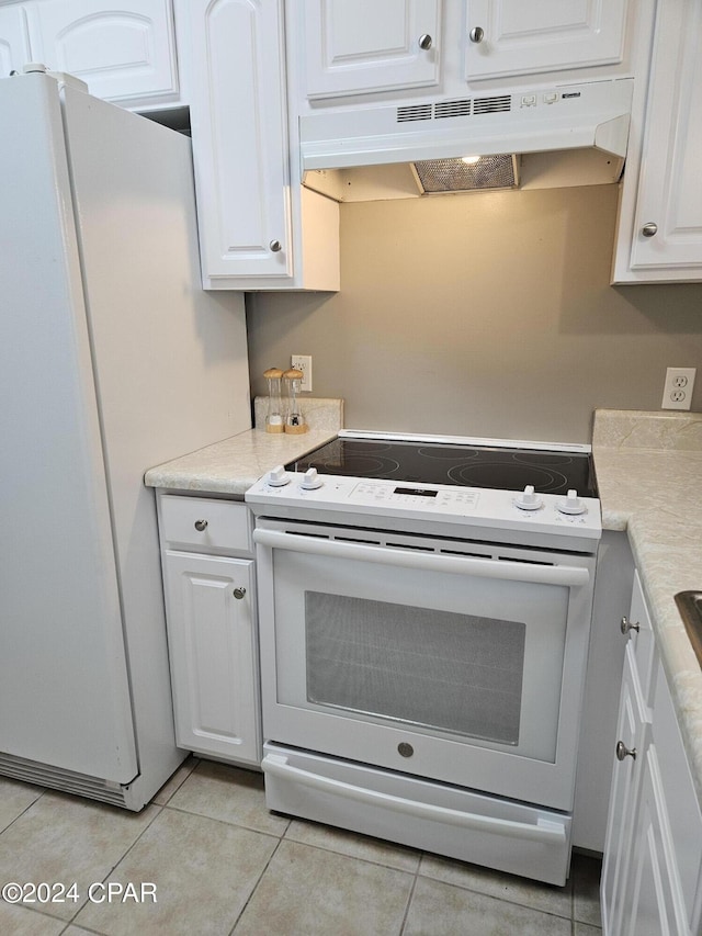 kitchen with under cabinet range hood, white appliances, white cabinets, and light countertops