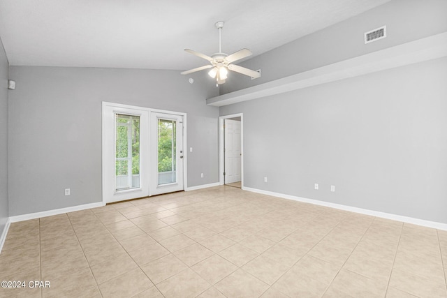 tiled empty room with visible vents, a ceiling fan, baseboards, and vaulted ceiling