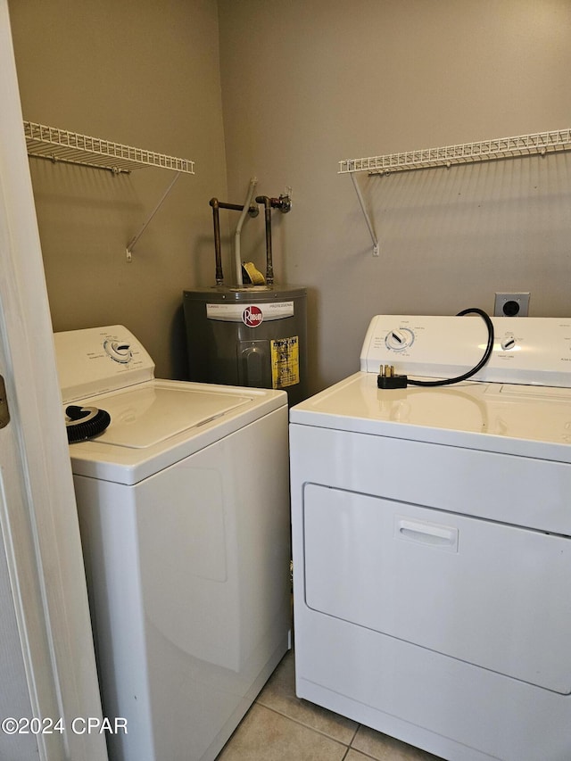 clothes washing area featuring light tile patterned floors, laundry area, independent washer and dryer, and electric water heater