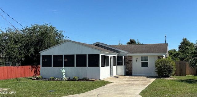 view of front of property featuring a front yard and a sunroom