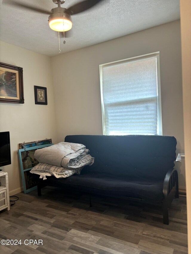 bedroom with wood-type flooring, ceiling fan, and a textured ceiling