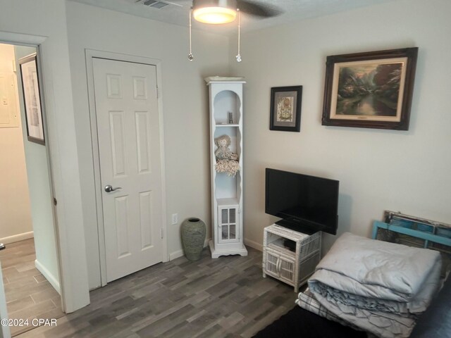 living area featuring hardwood / wood-style floors and ceiling fan