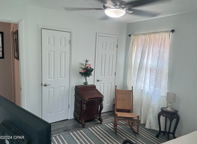 sitting room featuring ceiling fan and dark hardwood / wood-style floors