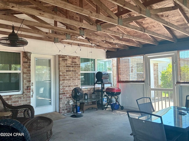 sunroom / solarium featuring lofted ceiling and a healthy amount of sunlight