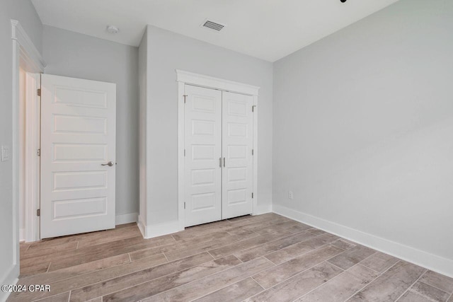 unfurnished bedroom featuring a closet and light hardwood / wood-style flooring