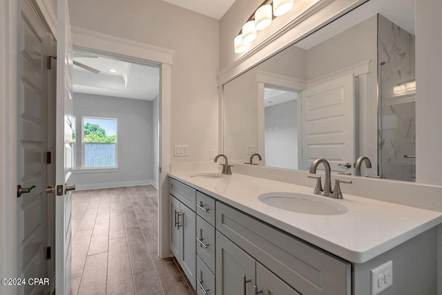 bathroom with wood-type flooring, vanity, a tray ceiling, and walk in shower