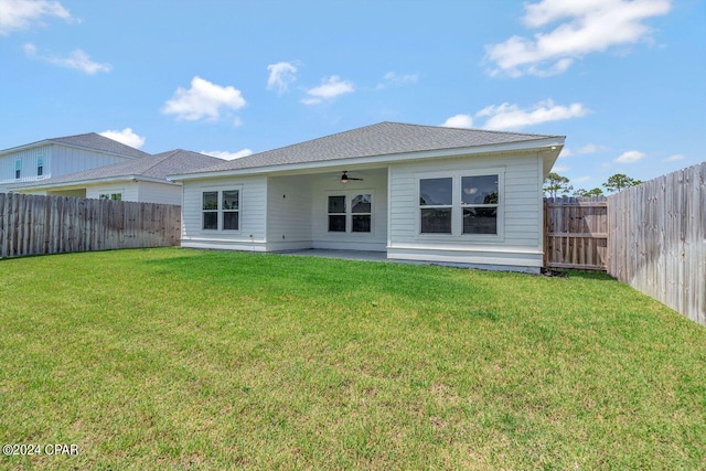 back of property with a lawn and ceiling fan