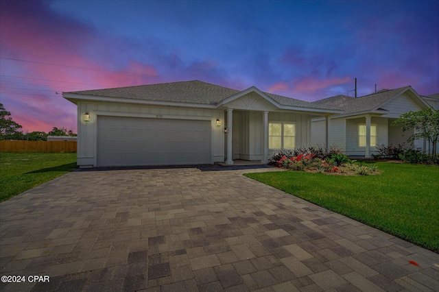 ranch-style house with a yard and a garage