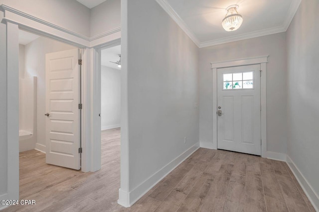 foyer featuring light hardwood / wood-style floors, an inviting chandelier, and crown molding