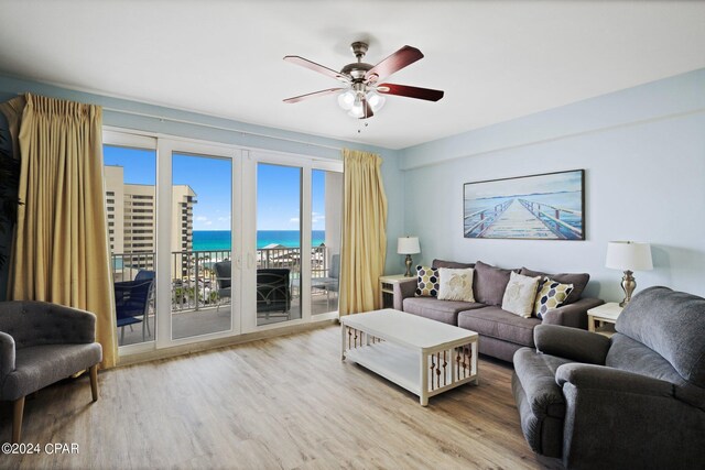 living room with a water view, hardwood / wood-style floors, and ceiling fan