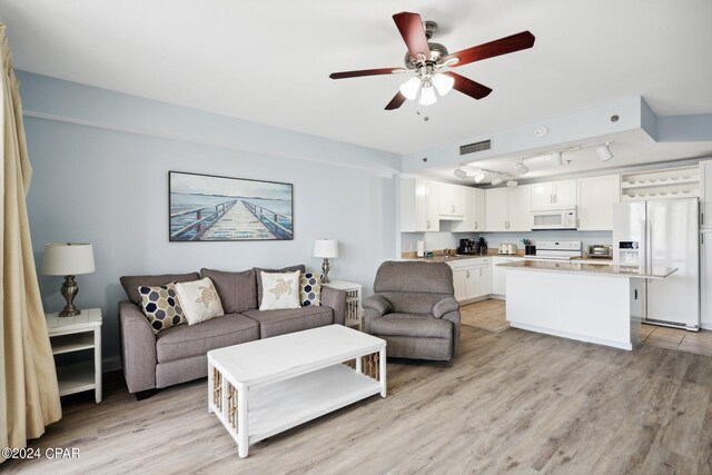 living room featuring light wood-type flooring, rail lighting, sink, and ceiling fan