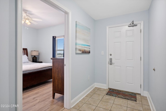 foyer entrance with ceiling fan and light tile patterned floors