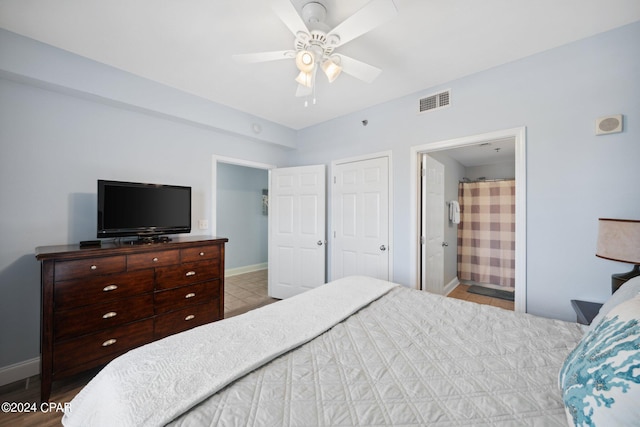 9860 S Thomas Dr Unit 519, Panama City, FL 32408 - bedroom with a ceiling fan, connected bathroom, baseboards, and visible vents