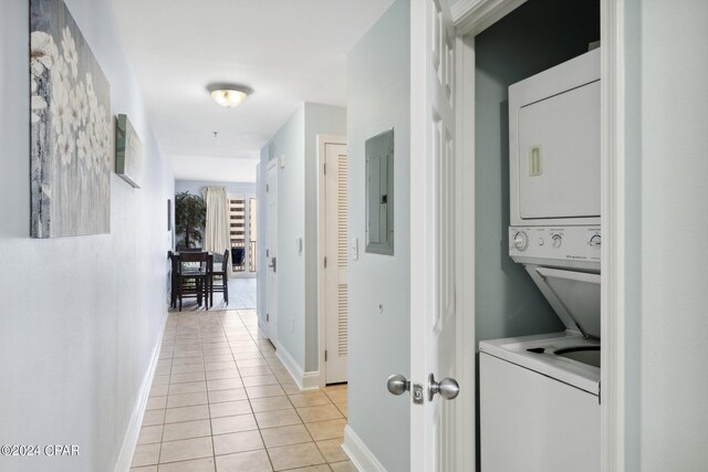 hallway with stacked washing maching and dryer, electric panel, and light tile patterned floors