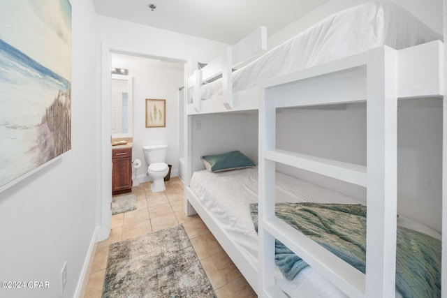 bedroom featuring light tile patterned flooring and connected bathroom