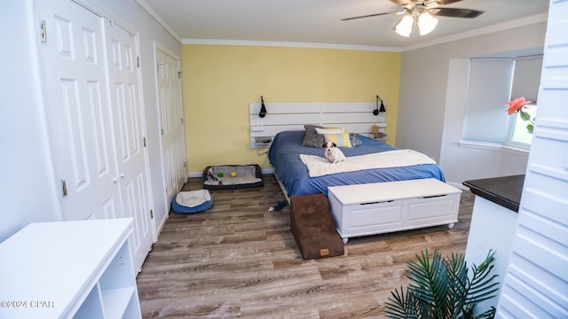 bedroom featuring ceiling fan, hardwood / wood-style floors, and crown molding