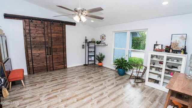 living area featuring light hardwood / wood-style flooring, vaulted ceiling, and ceiling fan